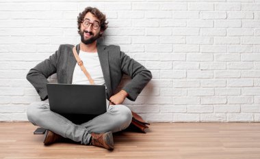 Şaka, komik, aptalca ve oynak bir ifadeyle dil yapışkanlık dışarı, bir aptal gibi seyir katta oturan genç adam.