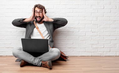 Şaka, komik, aptalca ve oynak bir ifadeyle dil yapışkanlık dışarı, bir aptal gibi seyir katta oturan genç adam.