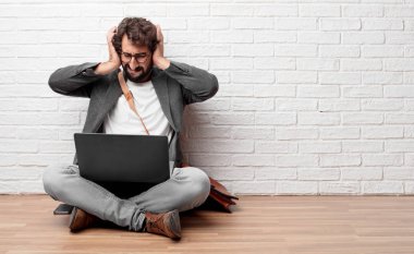 gürültü rahatsız edici bir rahatsız, yüksek sesle, onları korumak için kapak kulakları ile her iki katta oturan genç adam eller.