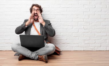 deli gibi yüksek sesle bağırarak, sinirli bir ifade ile el ile arama, büyük bir duyuru iletişim katta oturan genç adam.