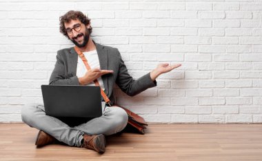 Genç adam ile gurur, memnun ve mutlu bir görünüm gülümseyen, karşılama jest veya gösterilen ve bir kavram tavsiye katta oturan sizi tebrik.