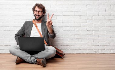 gurur, mutlu ve kendine güvenen bir ifade ile katta oturan genç adam; gülümseyen ve zafer kutluyor bir 