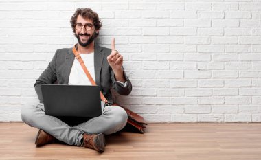 Genç adam gülümseyerek ve memnun ve mutlu, seyir katta oturan tek parmakla sayılması.