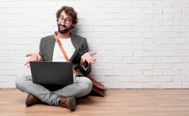 farklı seçenekler veya olanakları merak bir ifade ile arasında şüphe, karşılaştırma ve bir soru poz aklımda ve şaşkın bir bakışla katta oturan genç adam.