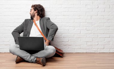 yere geri muhtemelen görünümü, iki elini akimbo poz ile kalça üzerinde oturan genç adam duygu gurur ve memnun.