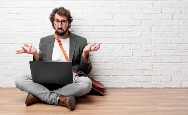 Genç adam yerde oturuyor. 