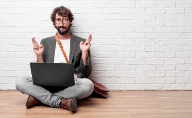 şans getirmesi için bir umut verici bir biçimde ile istekli ve heyecanlı ifade isteyen kat geçiş parmakları üzerinde oturan genç adam.