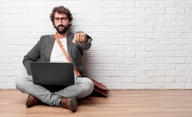 gücünü gösteren gurur, kendinden emin ve güçlü, kapalı yumruk ile meydan okurcasına, el hareketi seyir katta oturan genç adam.