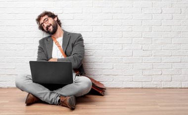 bir gurur, kendinden emin ve mutlu bir görünüm, gülümseyen ve duygu memnun, yanal veya yan görünümü ile katta oturan genç adam.