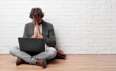 Genç adam bir aziz şekilde dua katta oturan 