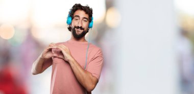 yana doğru ayakta, gülümseyen, mutlu ve sevgi arıyorum, bir kalp el ile şekil verme Genç sakallı adam. Yan veya yan görünüm.