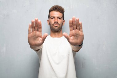 yakışıklı delikanlı sinyal dur her iki avuç içi ileri, ciddi ve sert bir ifade ile karşı karşıya eller ile yasaklayan.