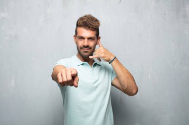 bir telefon görüşmesi jest veya işareti, gurur, mutlu, memnun bir bakışla yapma yakışıklı delikanlı; ileri doğru işaret eden bir gülümseme ile iletişim sunan.