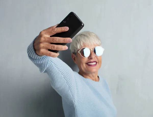 Senior Fajna Kobieta Smartfonem Ścianę Cementu Grunge — Zdjęcie stockowe
