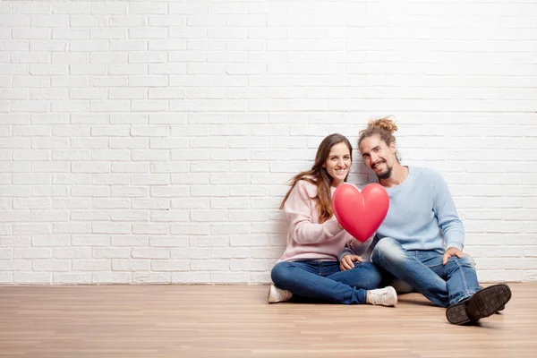 幸せな若いカップルが彼らの新しい家の床に座って 愛と家を移動の概念 — ストック写真
