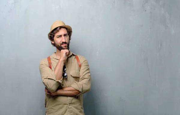 young traveler man or tourist With a confused and thoughtful look, looking sideways, thinking and wondering between different options.