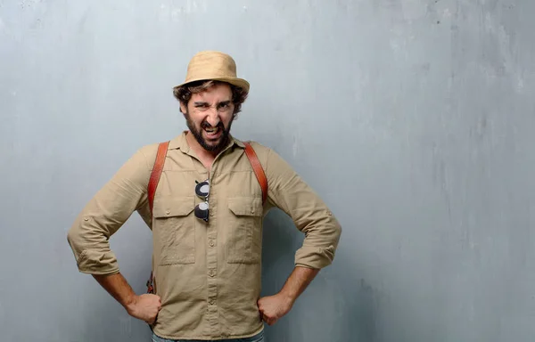 young traveler man or tourist looking angry, unhappy and frustrated, gesturing furiously, feeling upset and annoyed.