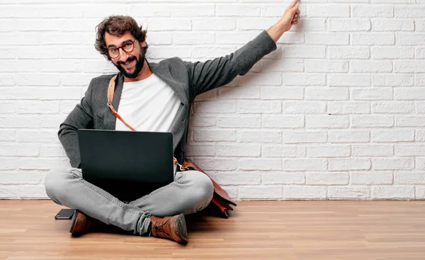 kat gülümseyerek oturan ve yukarı doğru nerede gazeteci bir kavram gösterebilir miyim yere doğru iki eliyle işaret eden genç adam.