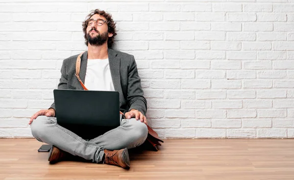 Genç adam stresli ve sinirli, seyir katta oturan iki elinizle açın, holding dehşet ve güvensizlik ifade etmek.