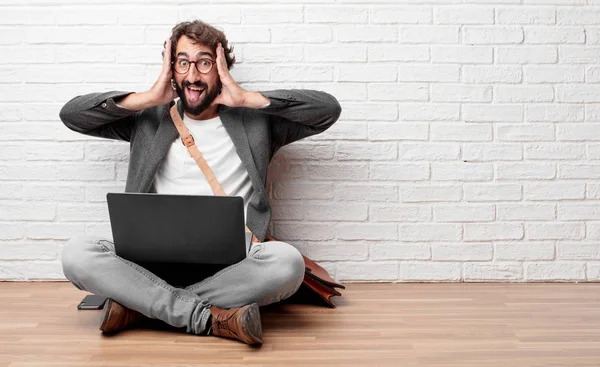 Şaka, komik, aptalca ve oynak bir ifadeyle dil yapışkanlık dışarı, bir aptal gibi seyir katta oturan genç adam.