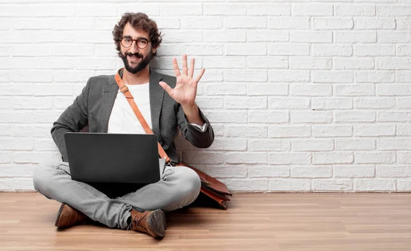 Beş parmaklı, avuç ile sayılması kat gülümseyerek oturan ve memnun ve mutlu, arayan genç adam.