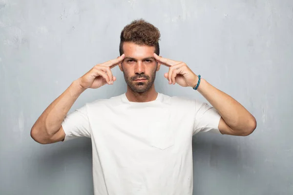 young handsome man With a confused and thoughtful look, looking sideways, thinking and wondering between different options.