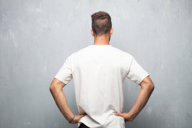 Genç yakışıklı adam geri görüntülemek, iki elini akimbo poz ile kalça üzerinde muhtemelen duygu gurur ve memnun.