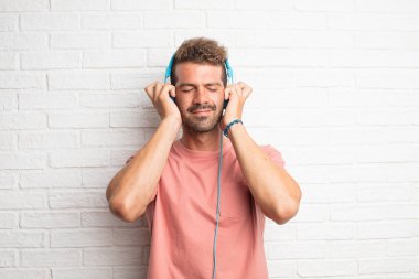 Genç yakışıklı adam kulaklık ile müzik dinleme serin