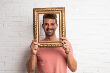 Genç yakışıklı serin adam Barok bir çerçeve ile şaka