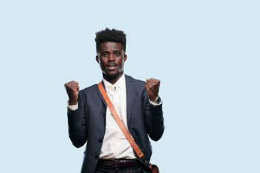 Genç siyah işadamı Gesturing zafer, yüz ve hava yumruk preslenmiş gösterme gücü veya başarı, her iki silah mutlu, gururlu ve memnun suratında bir başarı kutluyor.