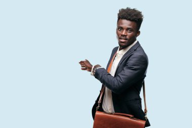 gülümseyen ve yukarı doğru nerede gazeteci bir kavram gösterebilir miyim yere doğru iki eliyle işaret eden genç siyah iş adamı.