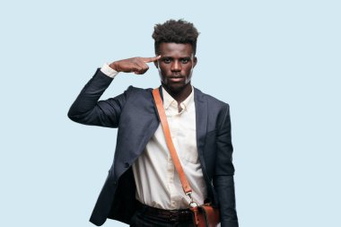 alnına basarak sıkılı yumruk ile düşünme de ciddi bir göz ile bir fikri üzerine konsantre ve aşağıya doğru bakan genç siyah işadamı.