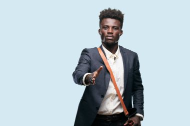 Anlaştık, kapanış veya selamlama ve sizi karşılayan bir el sıkışma, sunan ciddi, kendine güvenen, gurur ve sert bir ifade ile genç siyah işadamı.