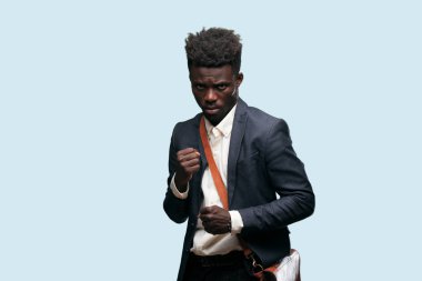 öfkeyle ve kati yumruk gösteren genç siyah işadamı ile bir öfkeli, agresif ve tehditkar poz, dövüş için hazır.