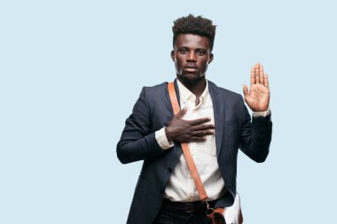 tek eliyle kalp üzerinde ciddiyetle küfür samimi söz ver yoksa yemin, yaparken güvenle gülümseyen genç siyah işadamı.