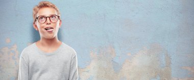 Şaka, komik, aptalca ve oynak bir ifadeyle dil yapışkanlık dışarı, bir aptal gibi arıyorum Genç sarışın yakışıklı çocuk.