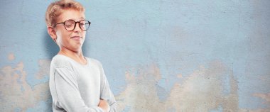 Genç sarışın yakışıklı çocuk gurur, mutlu ve kendine güvenen bir ifade ile; silah ile bir meydan okuma kabul, gülümseyen ve başarı, emin bir 
