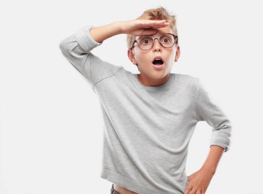 şaşkın bir bakışla uzak bir nesne için arama mesafe içine uzakta arıyorum Genç sarışın yakışıklı çocuk.