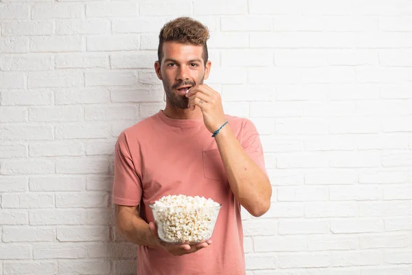 stock image young handsome cool man with popcorns. movie or film concept