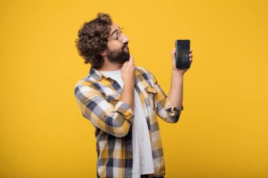 Genç deli deli adam aptal poz ile bir akıllı cep telefonu
