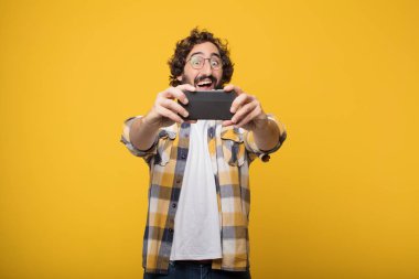 Genç deli deli adam aptal poz ile bir akıllı cep telefonu