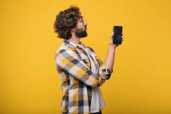 young crazy mad man in fool pose with a smart mobile phone