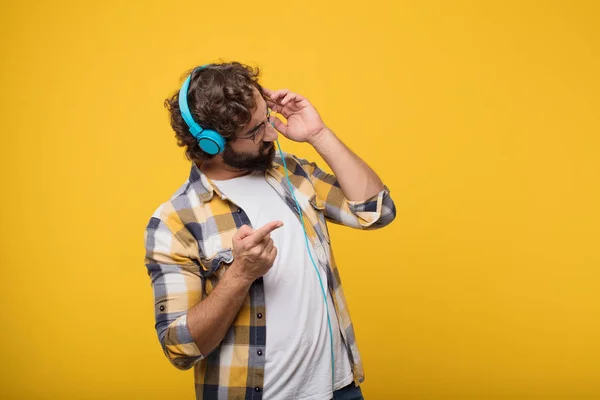 young crazy mad man in fool pose listening music with a headphones