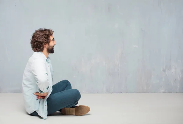 Young Cool Bearded Man Sitting Floor Grunge Wall Background — Stock Photo, Image