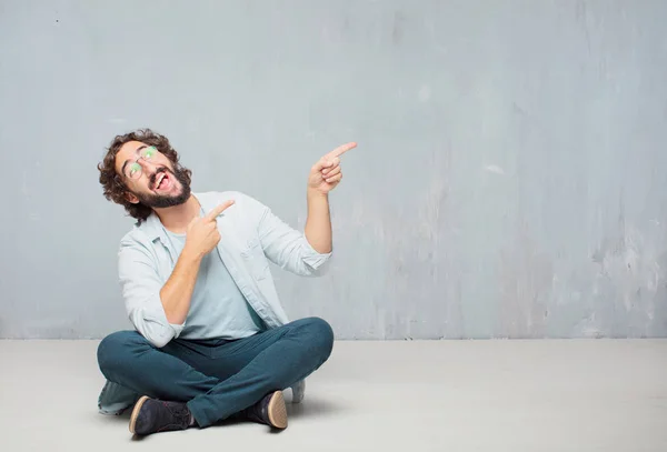 Joven Hombre Barbudo Fresco Sentado Suelo Fondo Pared Grunge —  Fotos de Stock