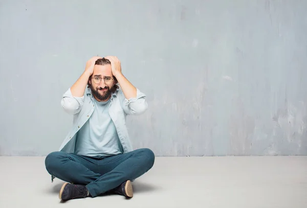 Jonge Cool Bebaarde Man Zittend Vloer Grunge Muur Achtergrond — Stockfoto