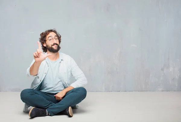 Young Cool Bearded Man Sitting Floor Grunge Wall Background — Stock Photo, Image