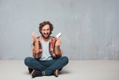aptal poz bir kredi kartı ile genç deli deli adam. Nakit veya para kavramı.