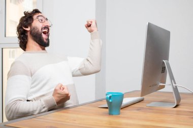 Genç sakallı deli freelancer onun bilgisayar ile çalışma