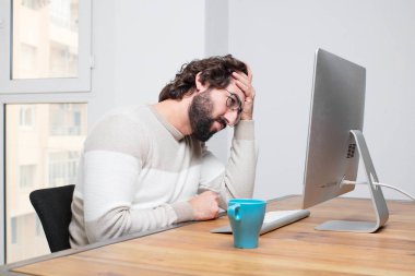 Genç sakallı deli freelancer onun bilgisayar ile çalışma